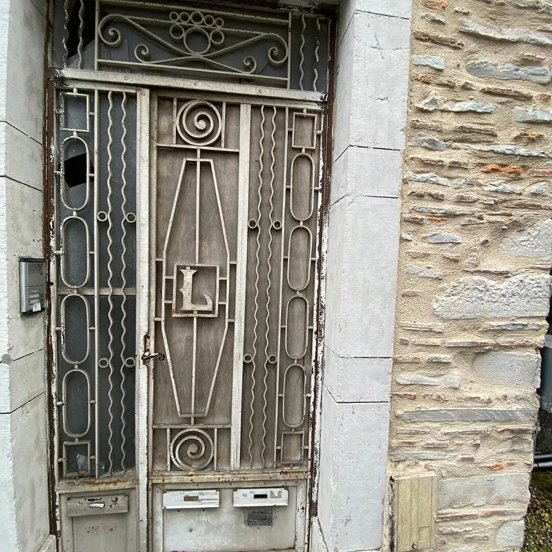 Avant : Ancienne porte d’entrée en fer forgé, vitre cassée, avant son remplacement